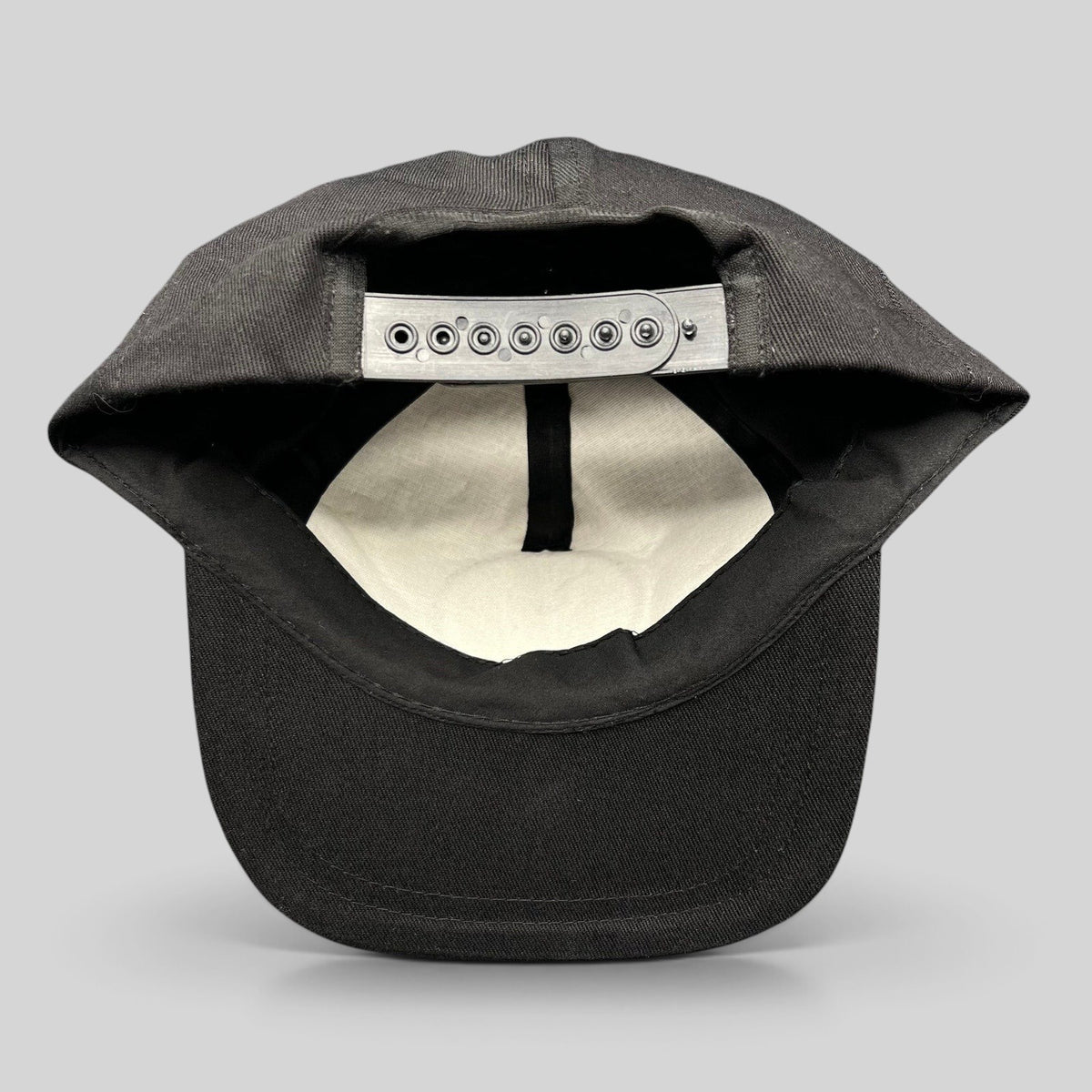 Raree Finds vintage black cotton snapback hat showing the interior plastic adjustable strap and structured crown
