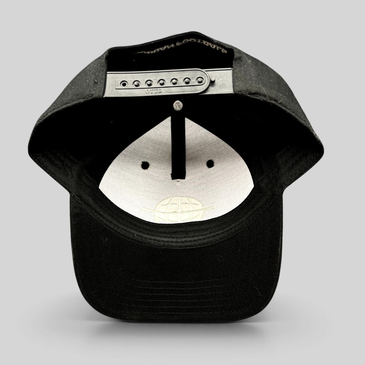 Raree Finds black snapback hat with adjustable strap and embroidered globe logo on the interior crown