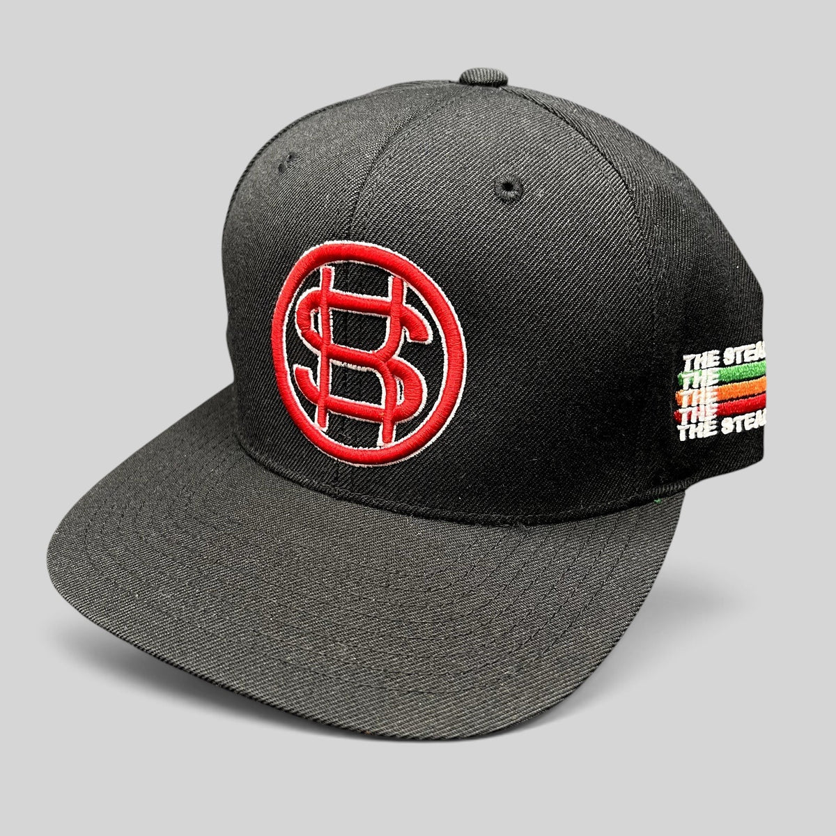 Raree Finds black Yupoong snapback hat with red P$ logo and multicolor side embroidery on a flat brim cap