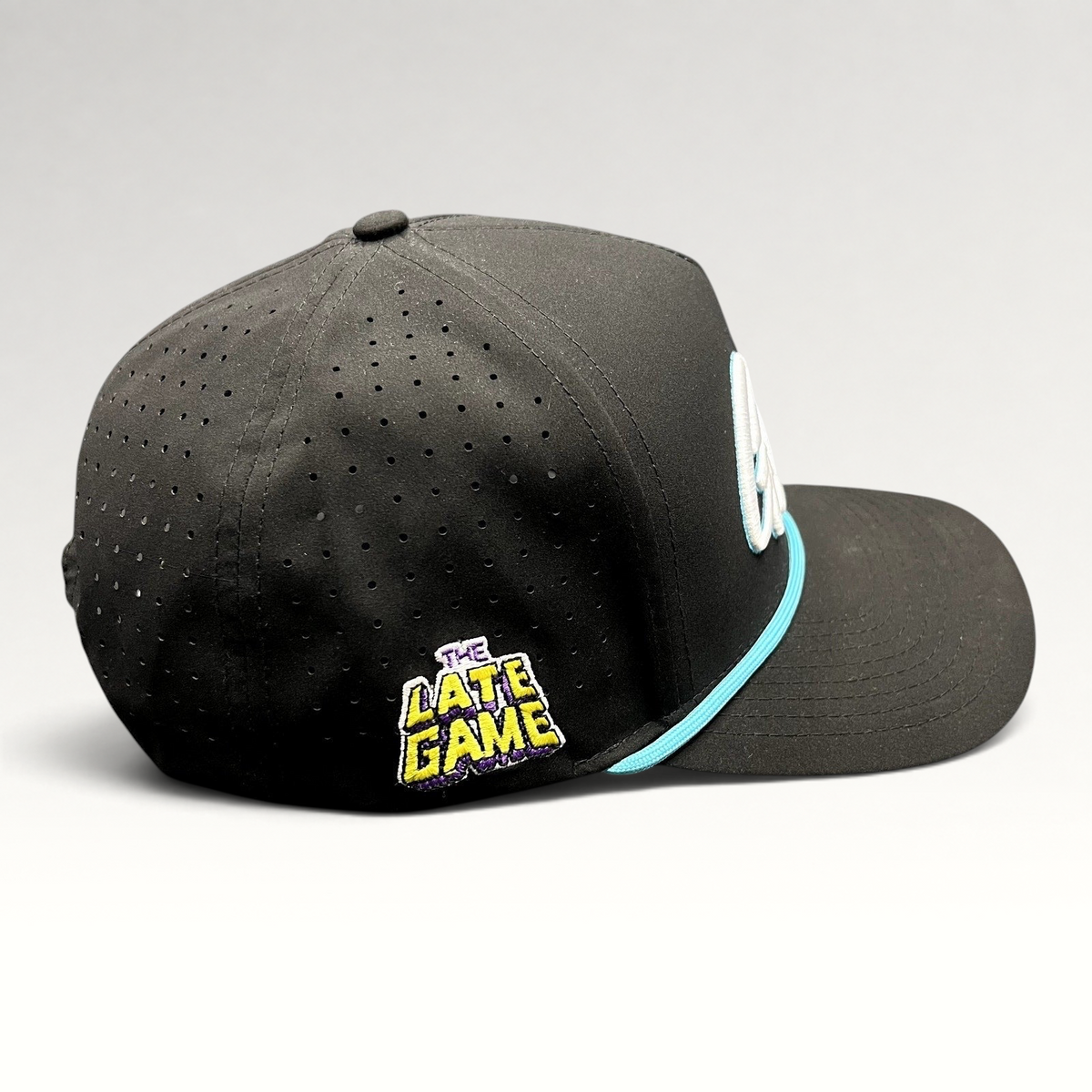 Raree Finds black snapback hat with perforated sides, teal rope, and The Late Game side embroidery.