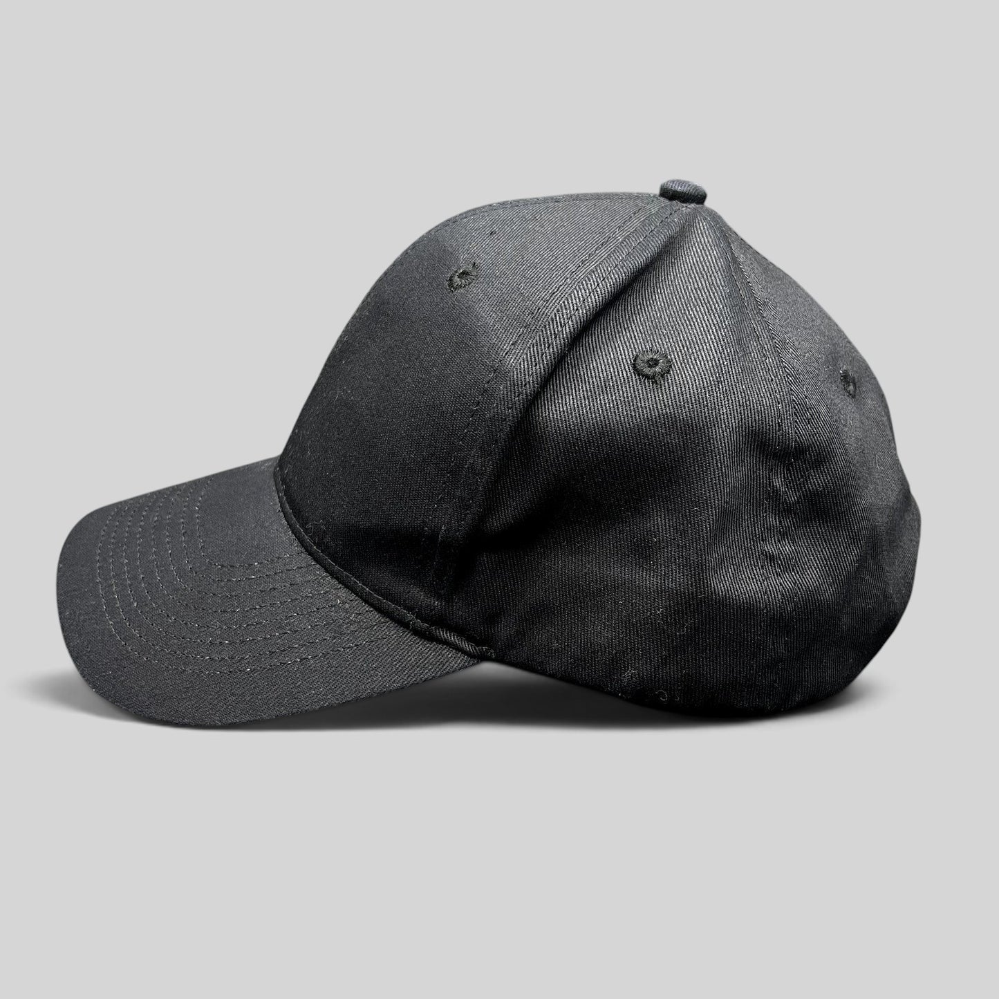 Raree Finds black KC Headwear snapback hat with a structured six-panel crown and pre-curved bill, side profile view.