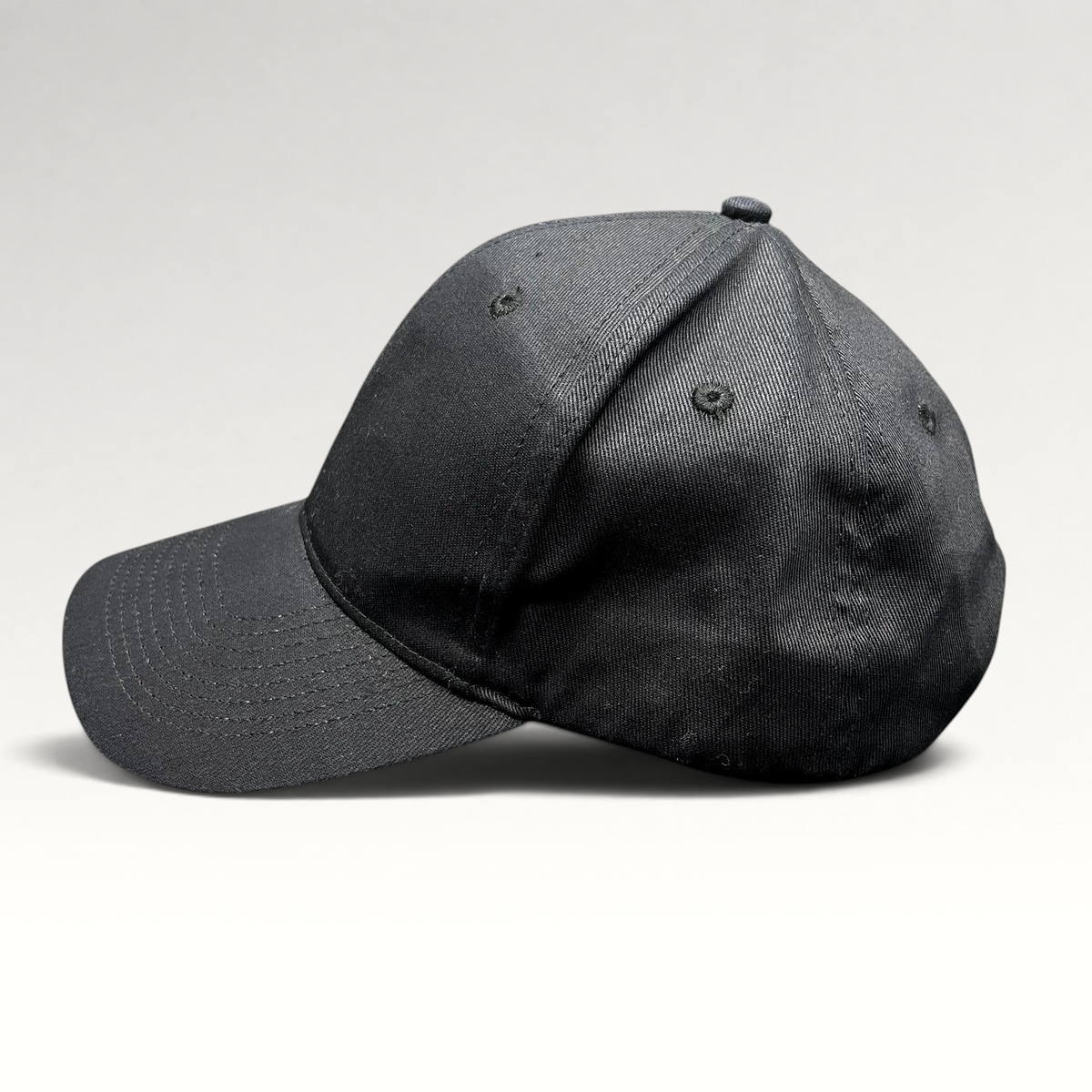 Raree Finds black KC Headwear snapback hat with a structured six-panel crown and pre-curved bill, side profile view.