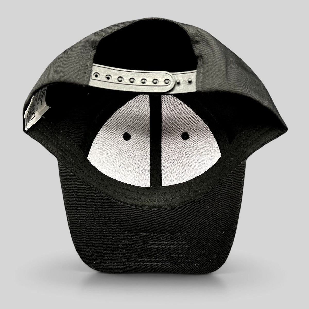 Raree Finds black snapback hat showing the interior adjustable plastic strap and white crown lining