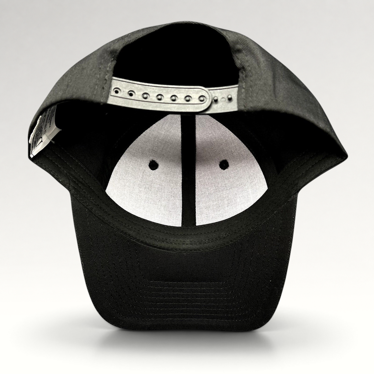 Raree Finds black snapback hat showing the interior adjustable plastic strap and white crown lining