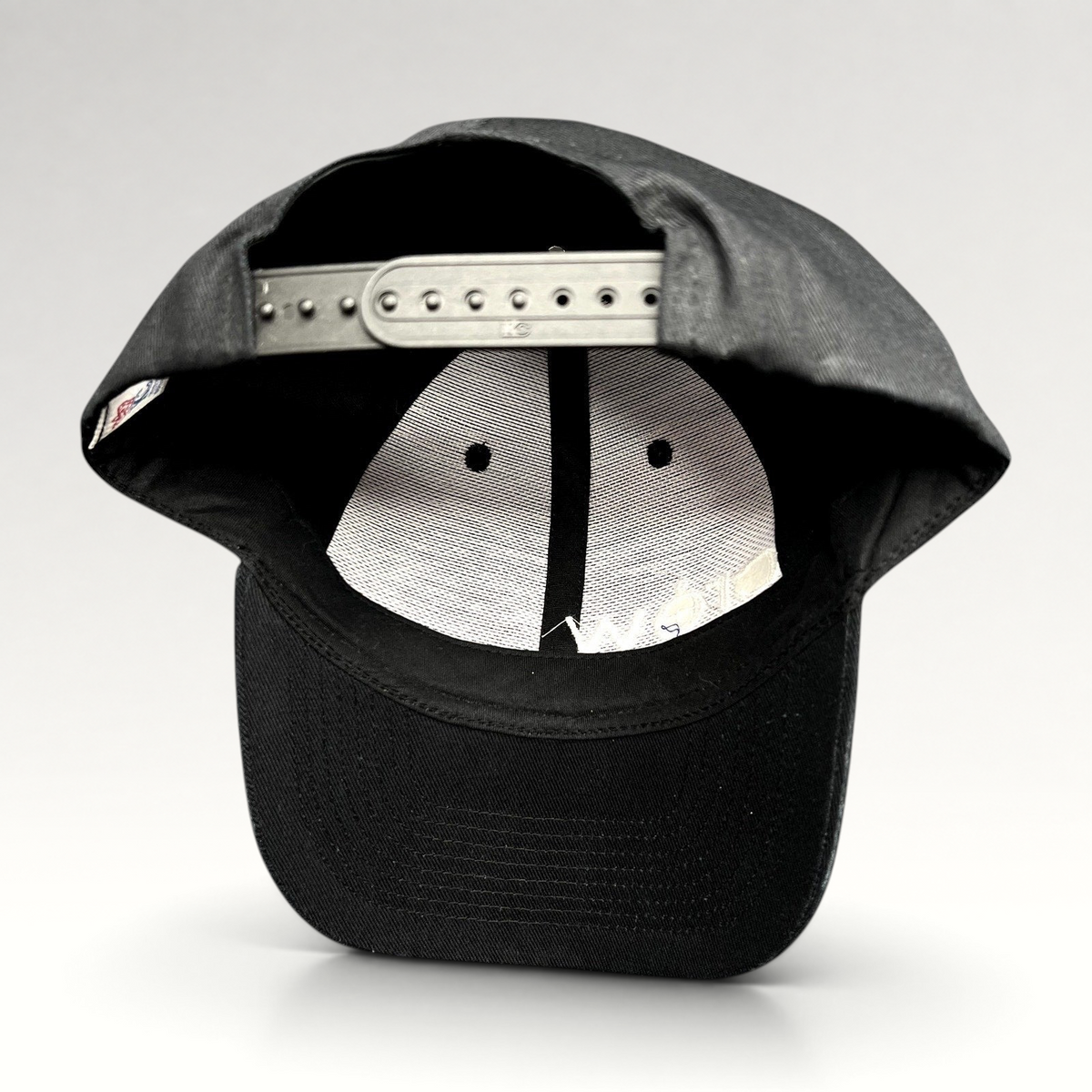 Raree Finds black KC Headwear snapback hat showing the interior six-panel construction and adjustable plastic closure