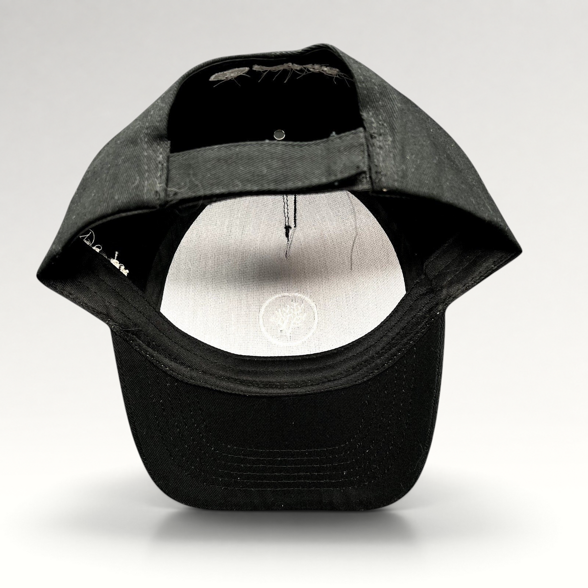 Raree Finds black Coral Gardeners strapback cap showing the adjustable rear strap and interior branding detail.