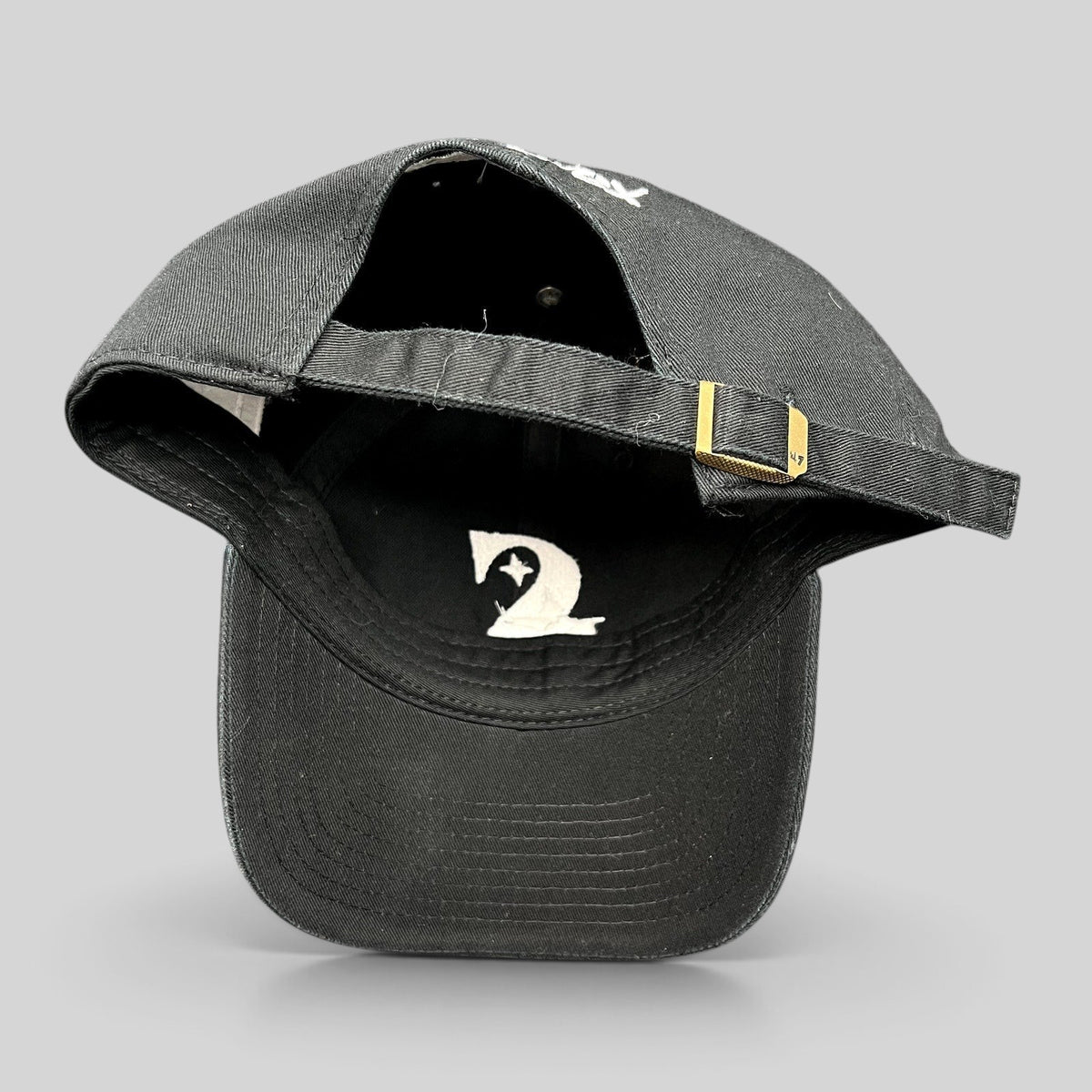 Raree Finds 47 Brand black cotton strapback hat with adjustable brass buckle and white interior logo detail