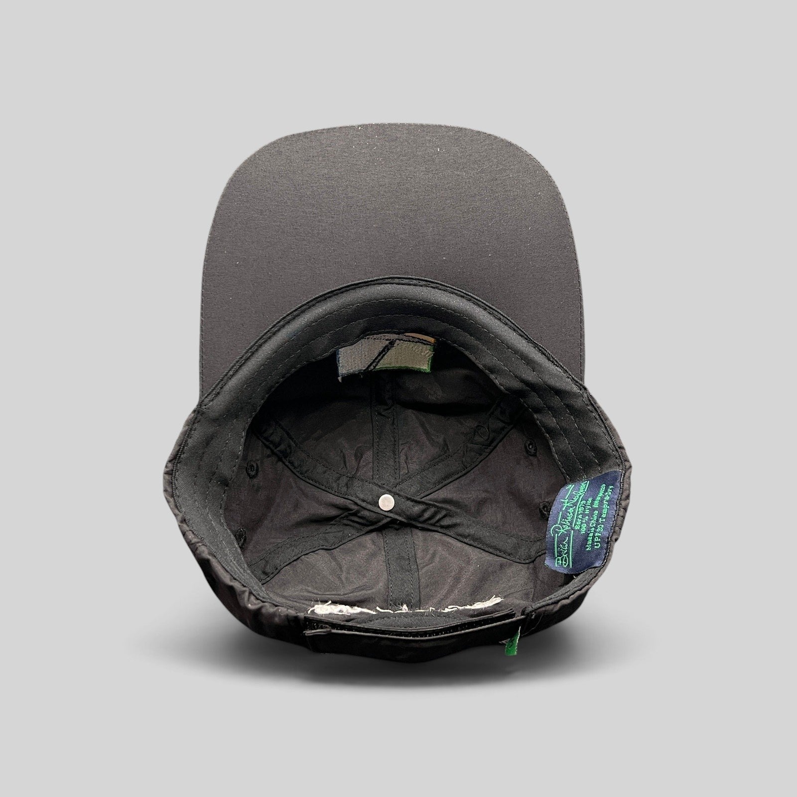 Raree Finds black unstructured strapback hat interior showing performance fabric lining and branded tag