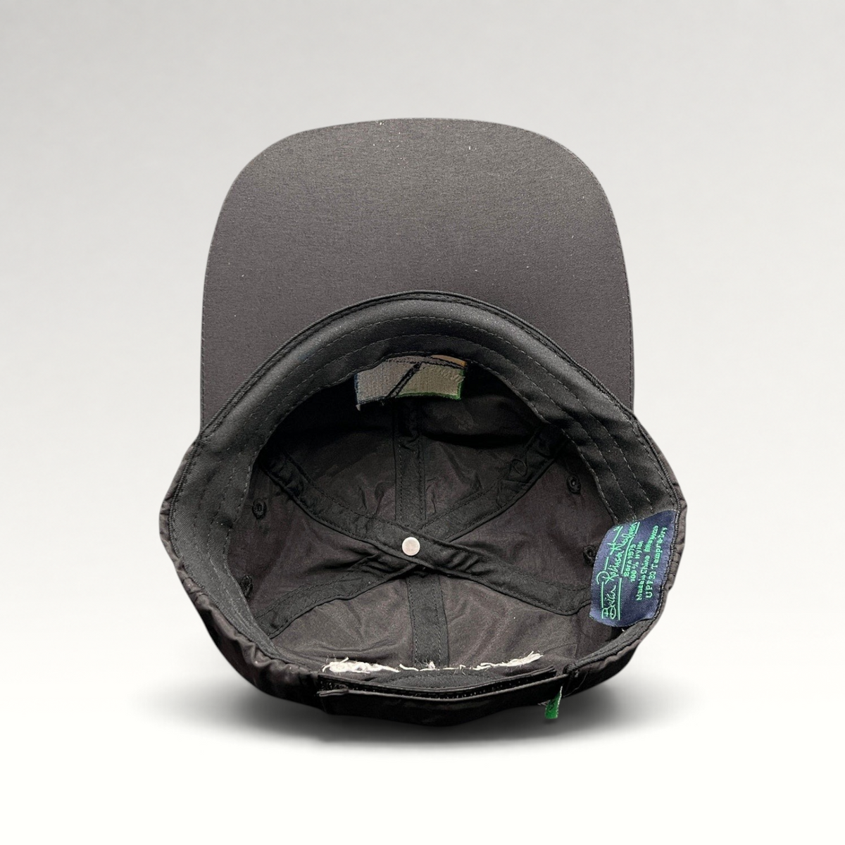 Raree Finds black unstructured strapback hat interior showing performance fabric lining and branded tag