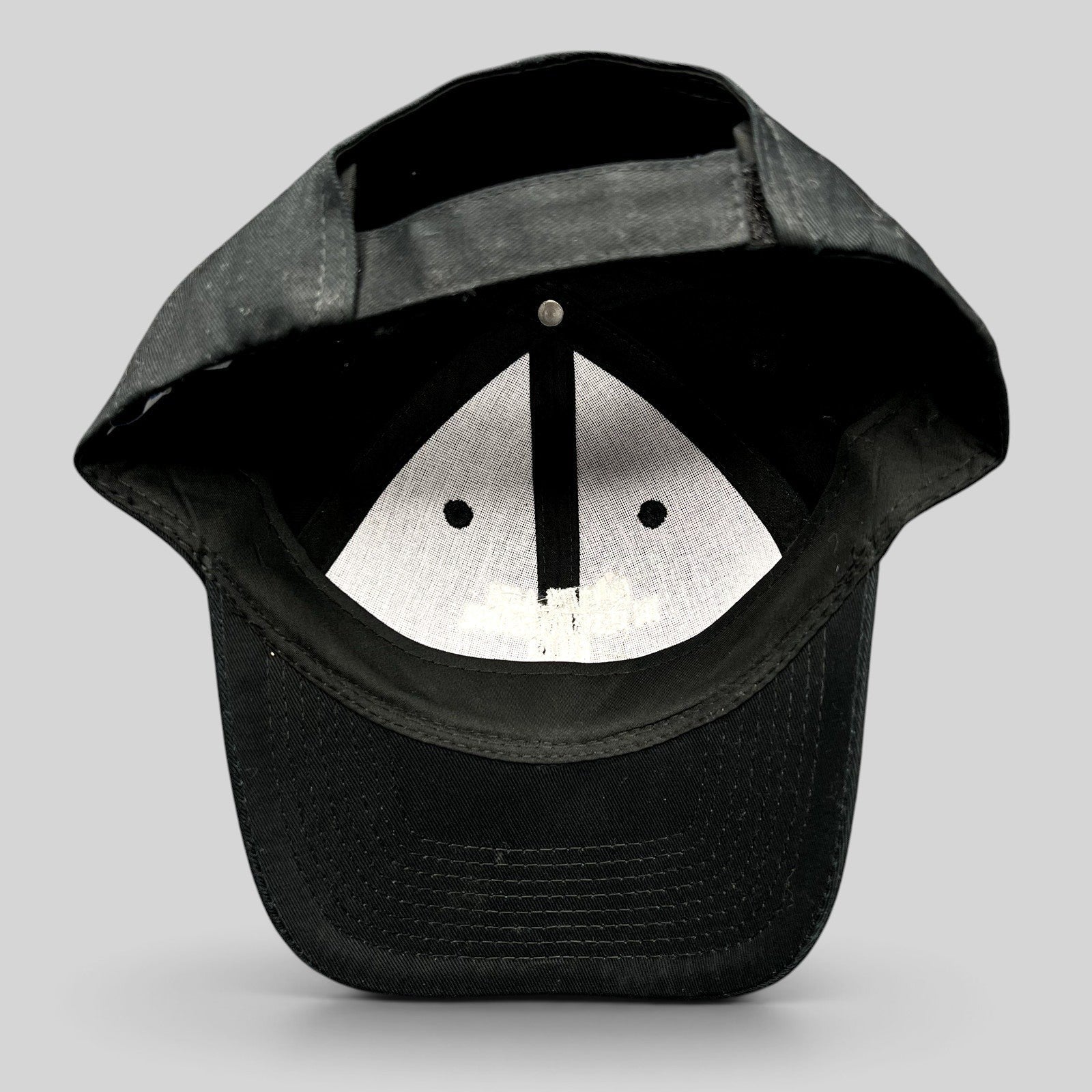 Raree Finds black Port & Company strapback hat showing the interior construction and adjustable back closure