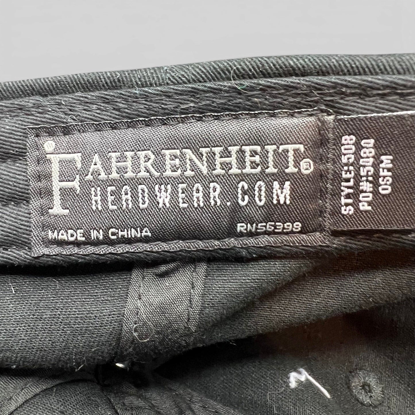 Raree Finds black cotton strapback hat interior label showing Fahrenheit Headwear branding and manufacturing details