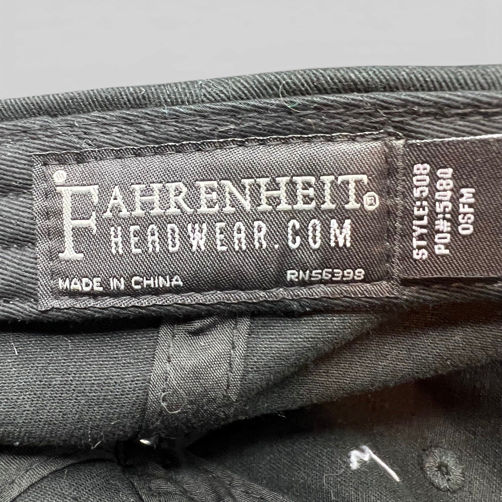 Raree Finds black cotton strapback hat interior label showing Fahrenheit Headwear branding and manufacturing details
