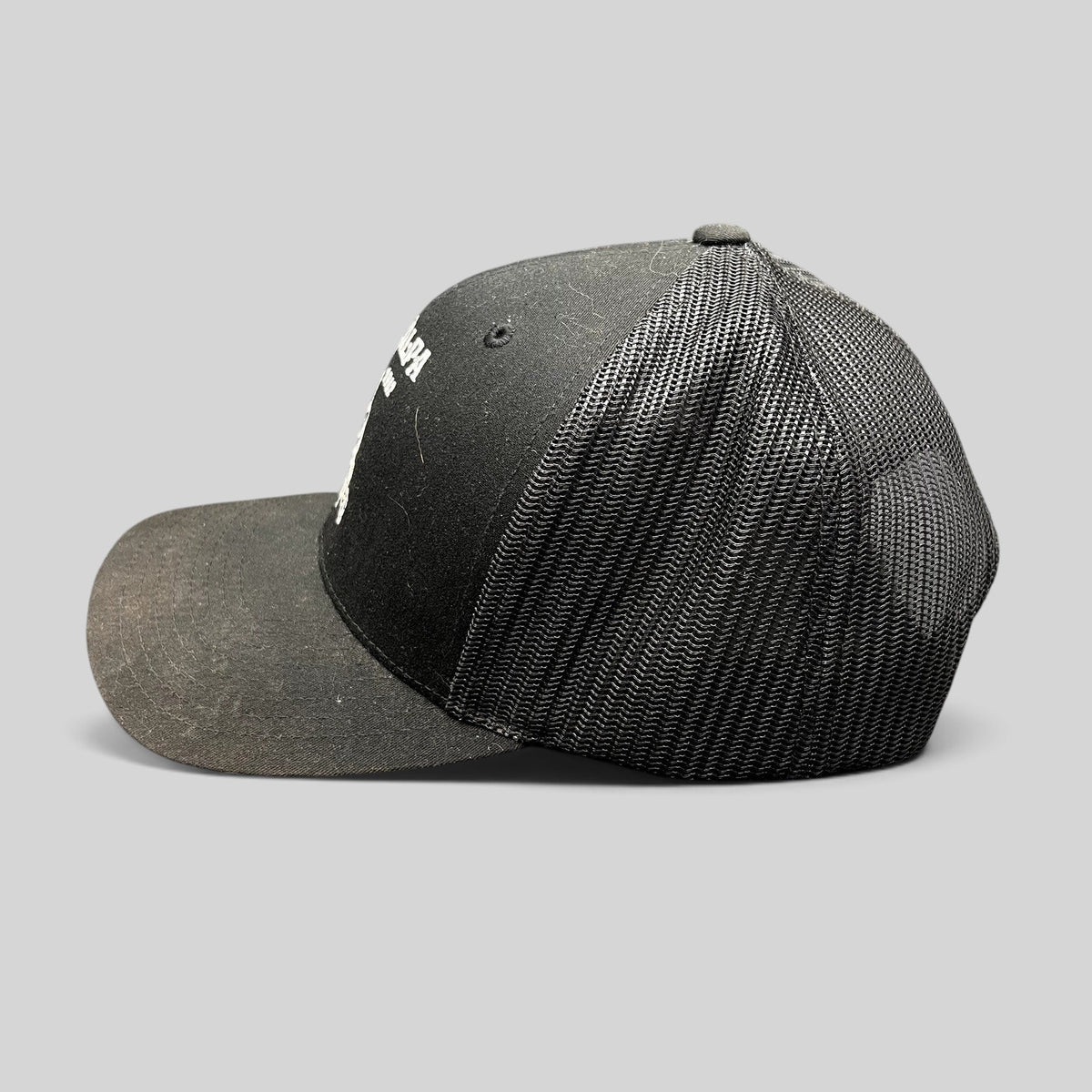 Raree Finds black Yupoong trucker snapback hat with The Talpa Est. 1962 embroidered cactus logo, side profile view.