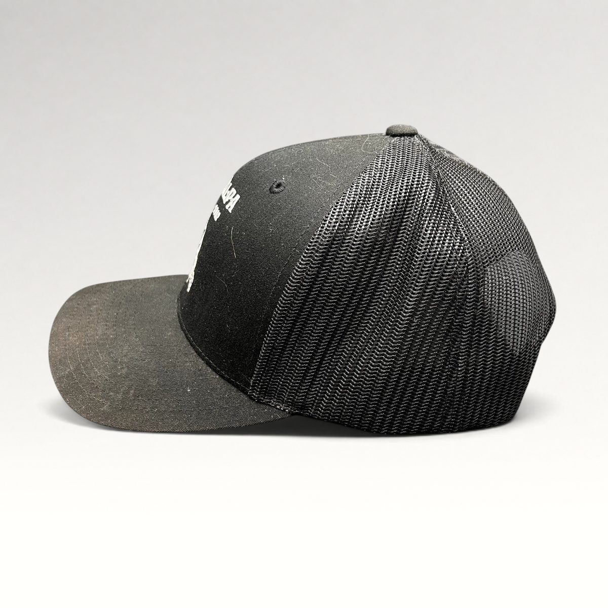 Raree Finds black Yupoong trucker snapback hat with The Talpa Est. 1962 embroidered cactus mascot logo, side profile.
