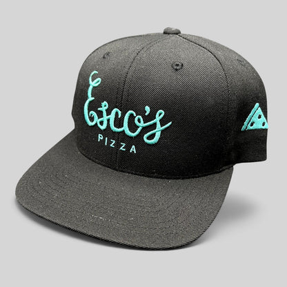 Raree Finds black snapback hat with teal Esco’s Pizza script embroidery and a pizza slice detail on the side.