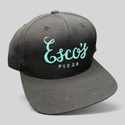 Raree Finds black snapback hat with teal Esco’s Pizza script embroidery on the front and a flat brim.