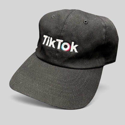 Raree Finds black cotton dad cap with embroidered TikTok logo in white, teal, and pink on an unstructured crown.