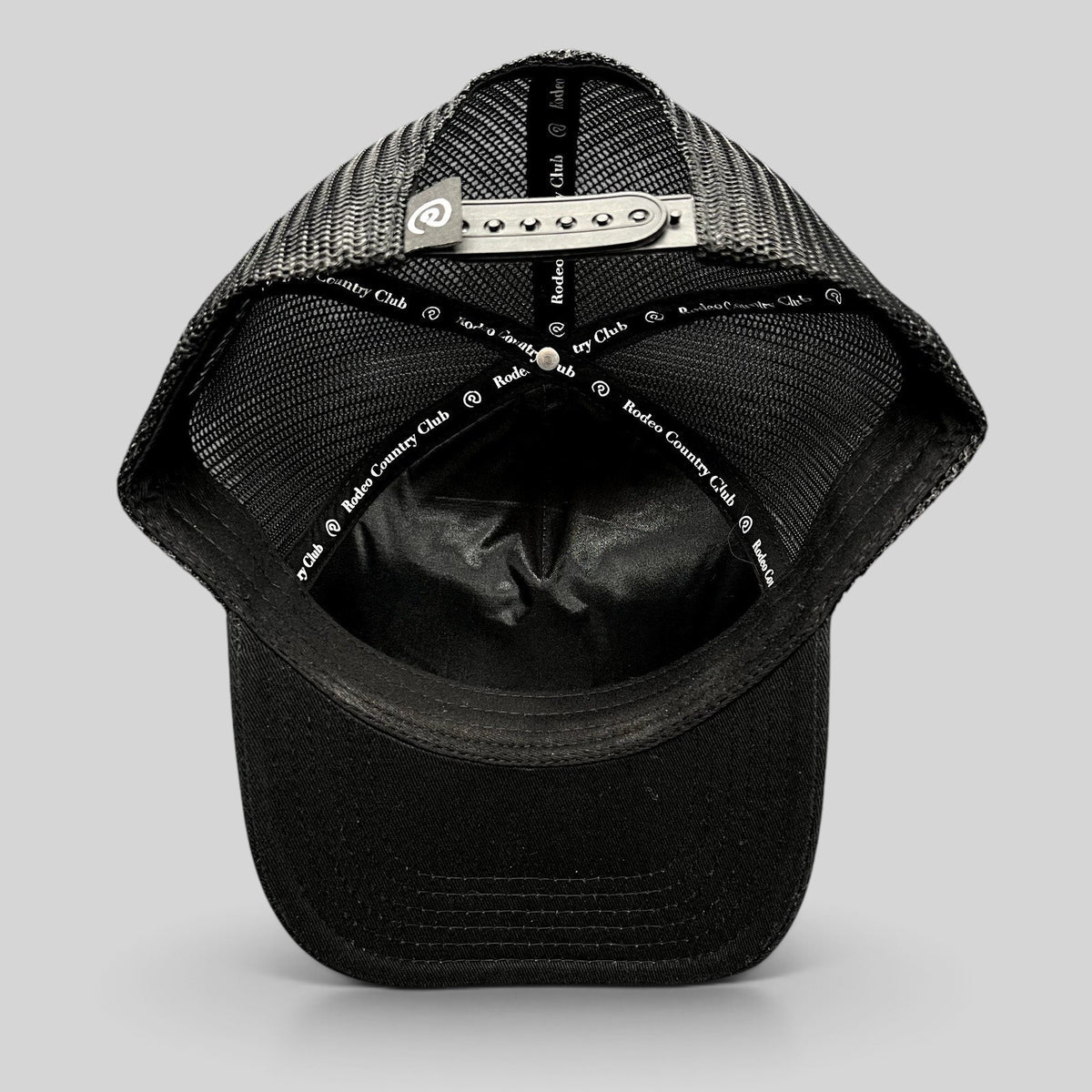 Raree Finds black Rodeo Country Club trucker hat showing interior mesh panels and adjustable snapback closure
