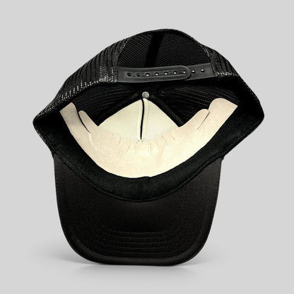 Raree Finds black Otto trucker hat interior view showing mesh back panels, foam front lining, and snapback closure.