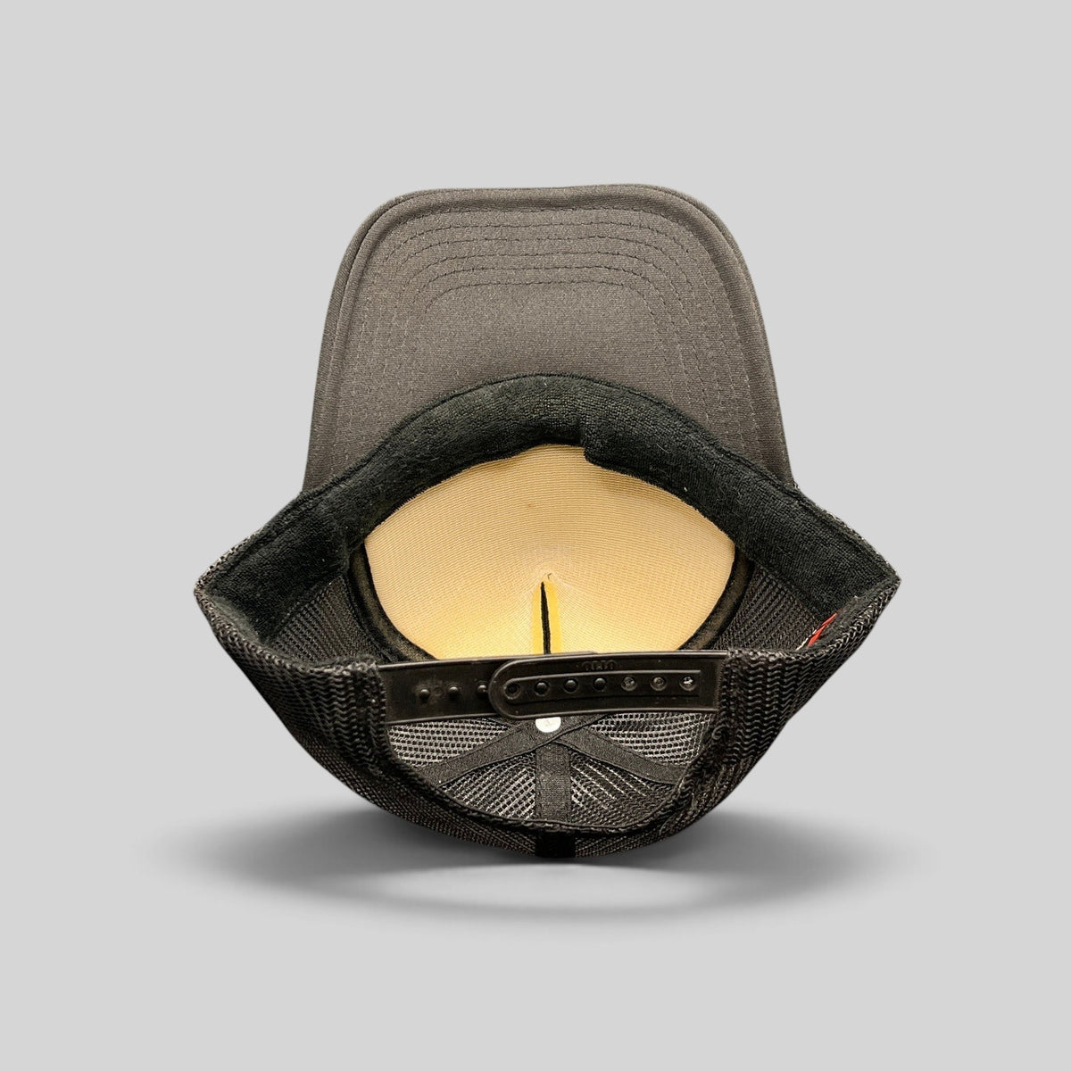 Raree Finds Doheny Room black trucker hat interior view showing foam lining, mesh back, and adjustable snapback strap.