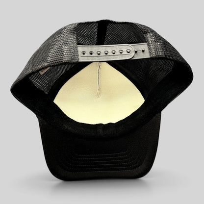 Raree Finds black trucker hat with mesh back and adjustable snapback closure, interior view showing foam lining.