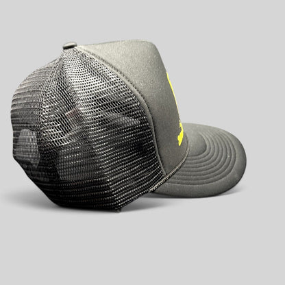 Raree Finds black foam trucker hat with yellow graphic, mesh back, and braided rope detail on the brim.