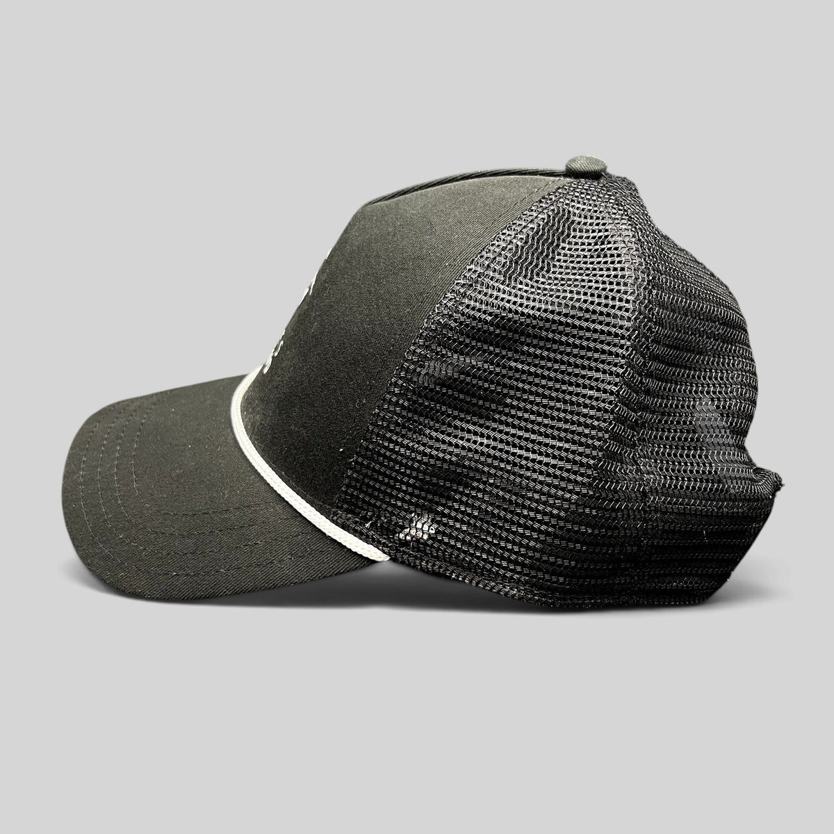 Raree Finds black trucker hat with breathable mesh back, white rope detail, and curved bill from Discovery Collection.