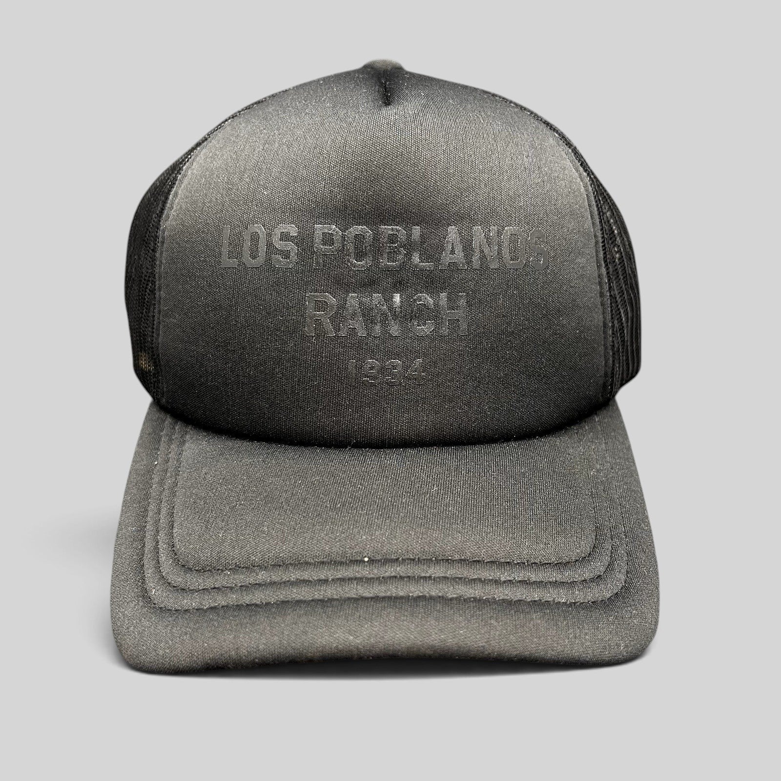 Raree Finds black Los Poblanos Ranch 1934 trucker hat with foam front panel, mesh back, and tonal branding.