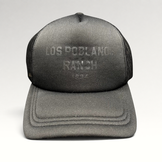 Raree Finds black Los Poblanos Ranch 1934 trucker hat with foam front panel, mesh back, and tonal branding.