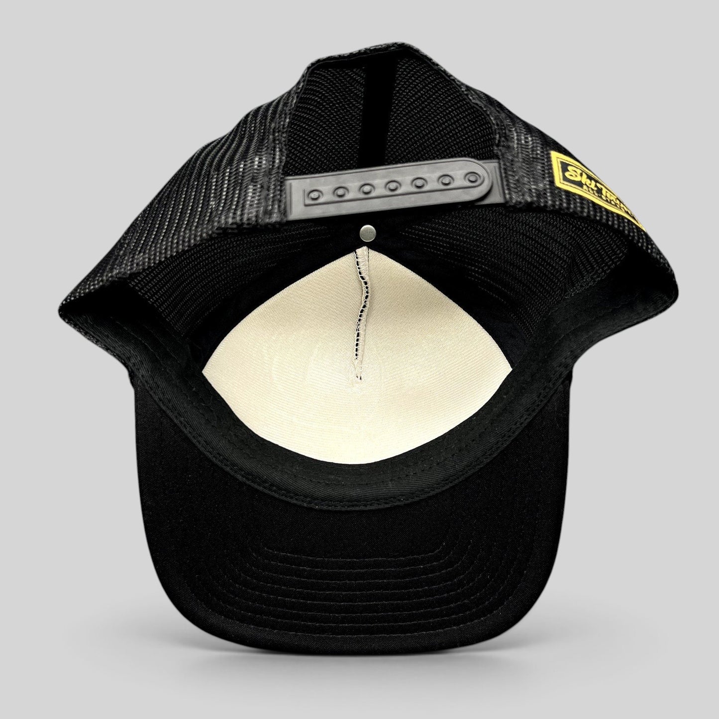 Raree Finds black mesh trucker hat with adjustable snapback closure and interior foam lining, back view