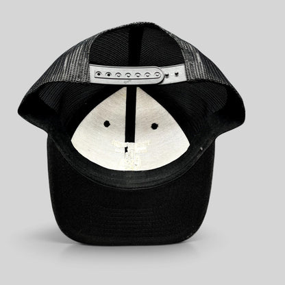 Raree Finds black Yupoong trucker snapback hat showing the interior mesh lining and adjustable plastic strap