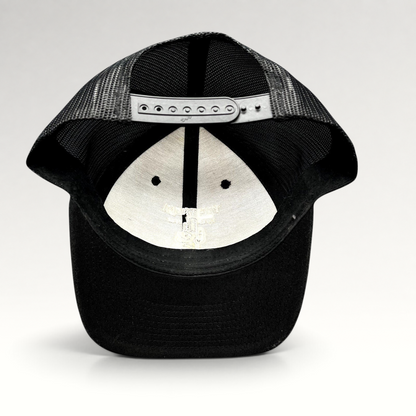 Raree Finds black Yupoong trucker snapback hat showing the interior mesh back and adjustable plastic strap