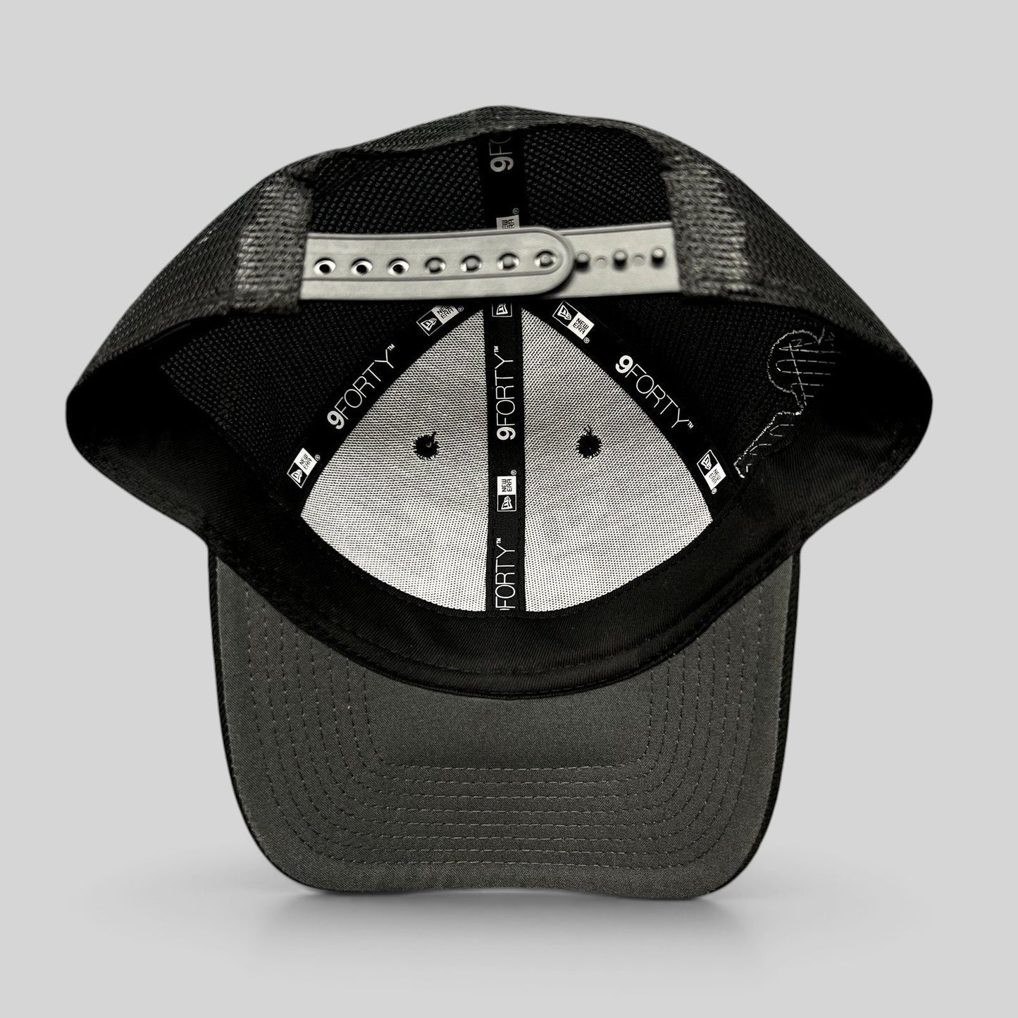 Raree Finds black New Era 9FORTY trucker snapback hat interior view showing mesh back and adjustable strap