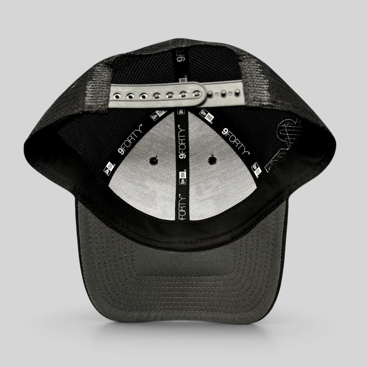 Raree Finds black New Era 9FORTY trucker snapback hat interior view showing mesh back and adjustable strap