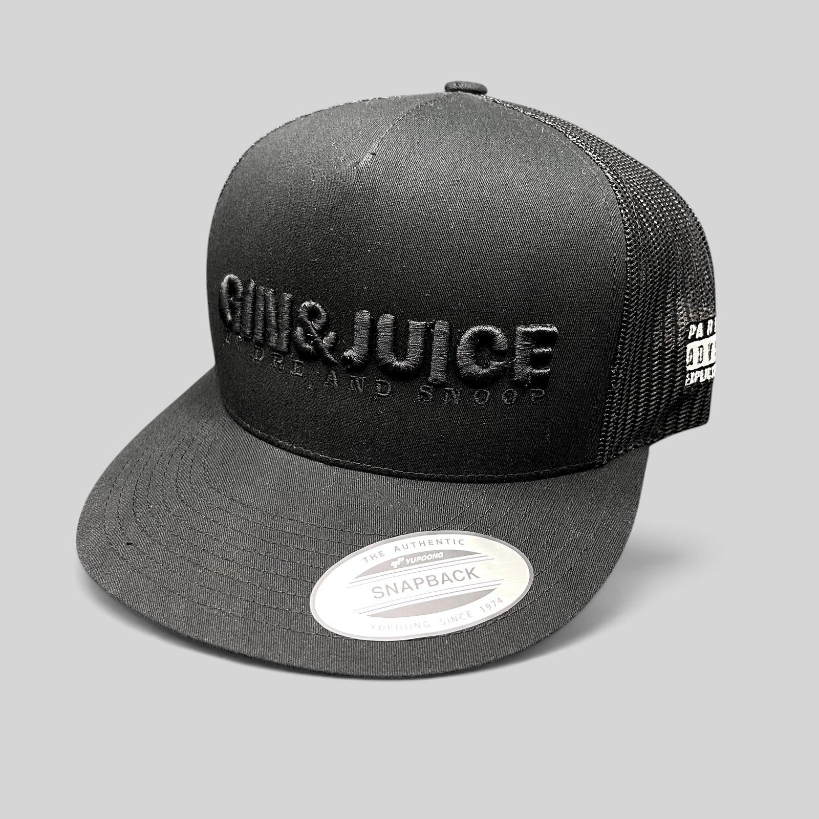 Raree Finds Gin & Juice black trucker snapback hat with raised tonal embroidery and breathable mesh back panels.
