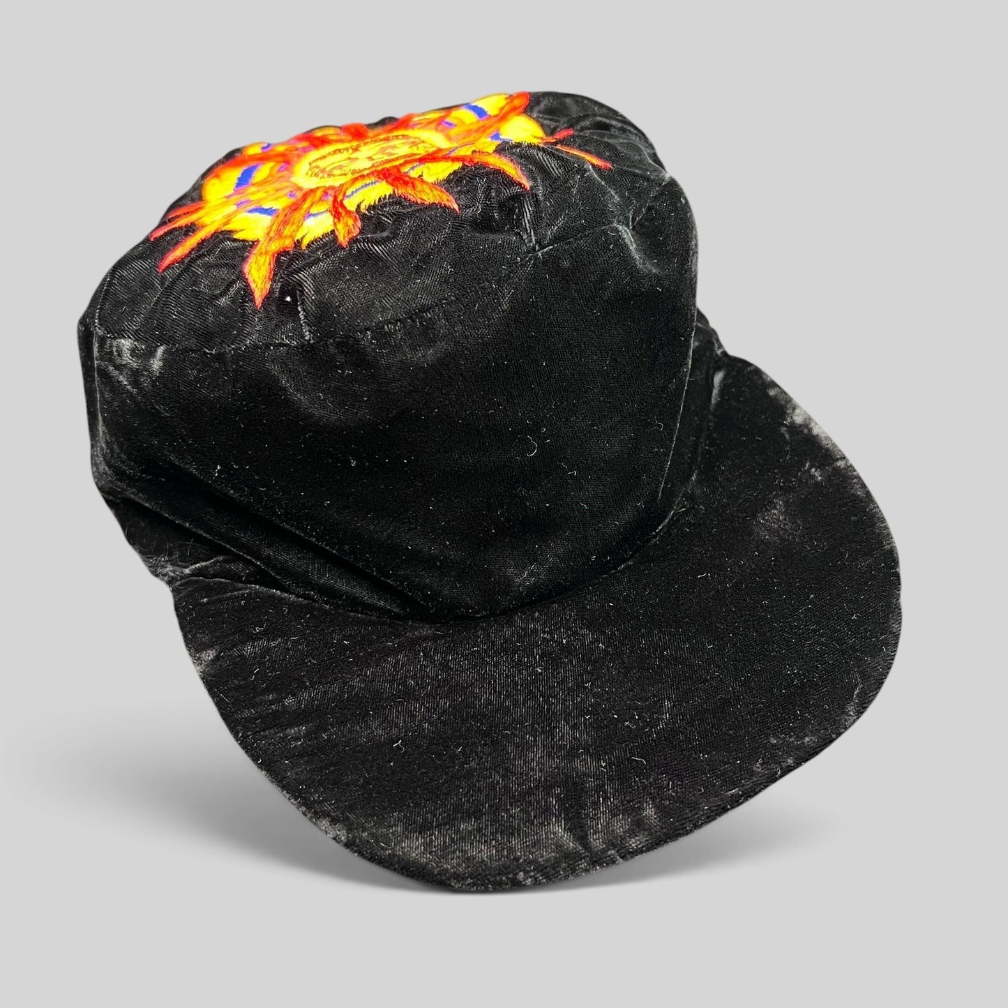 Raree Finds vintage black velvet cap featuring a colorful embroidered southwestern sun face motif on the crown.