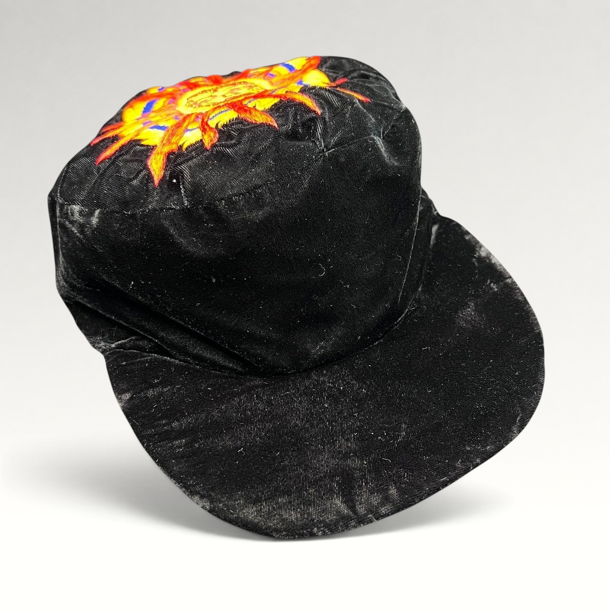 Raree Finds vintage black velvet cap featuring a colorful embroidered southwestern sun face motif on the crown.