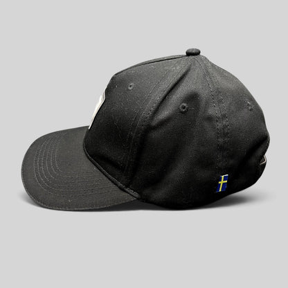 Raree Finds black organic cotton Volvo Iron Mark baseball cap with a small Swedish flag side tag, side profile view.