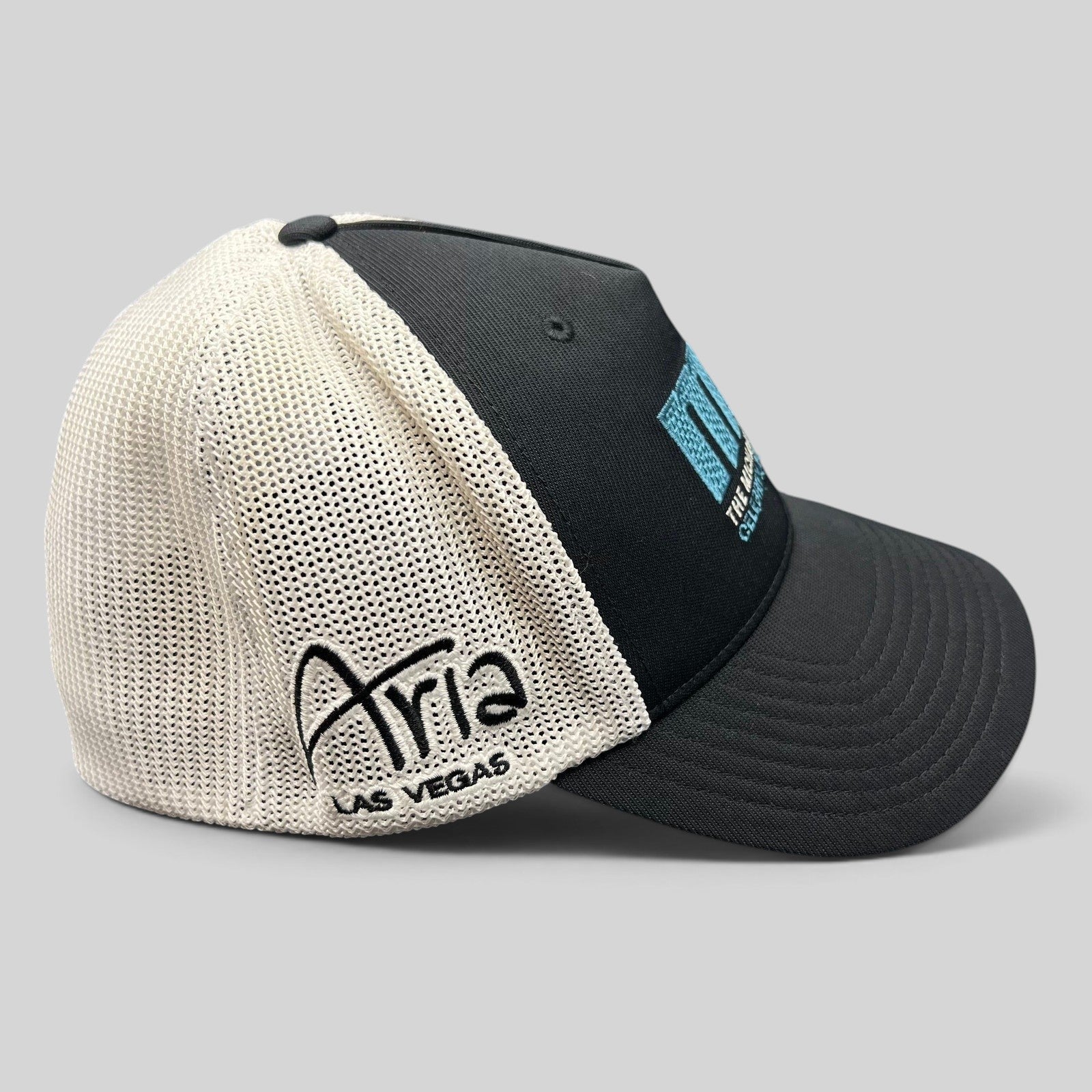 Raree Finds black and white mesh Flexfit golf hat featuring Aria Las Vegas embroidery and MJ Invitational logo