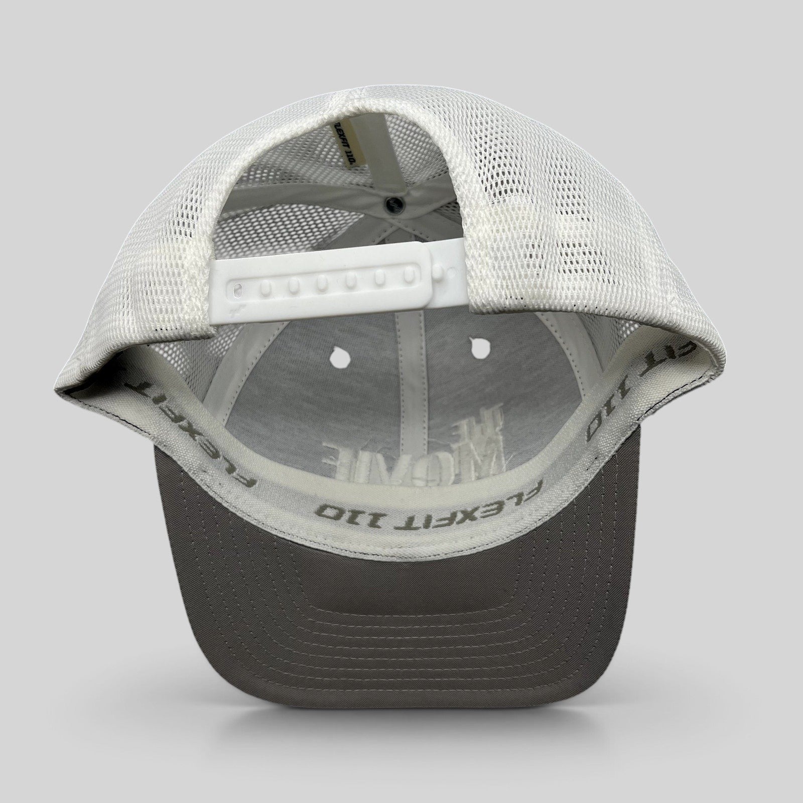 Raree Finds The Movie Guys black and white Flexfit 110 trucker hat with adjustable snapback and breathable mesh back
