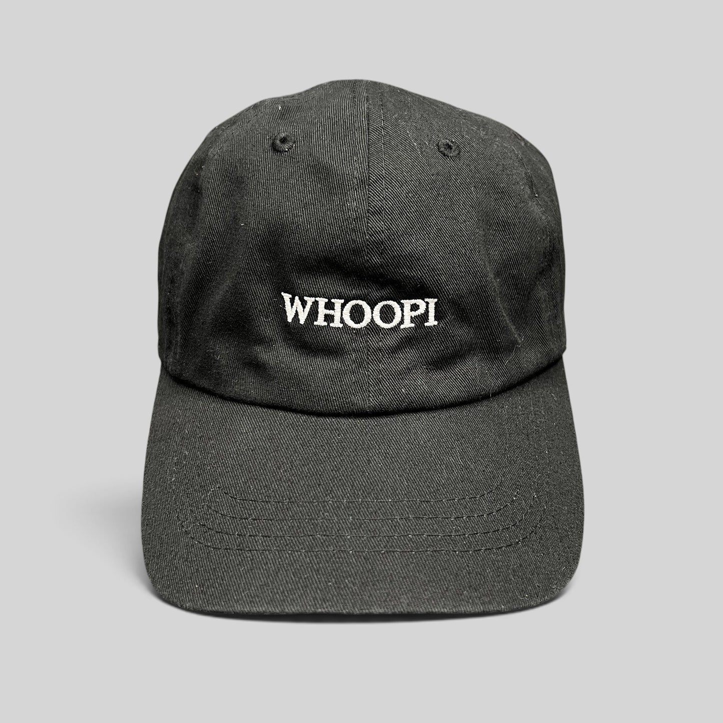 Raree Finds black organic cotton dad cap with white WHOOPI embroidery on the front and a curved brim