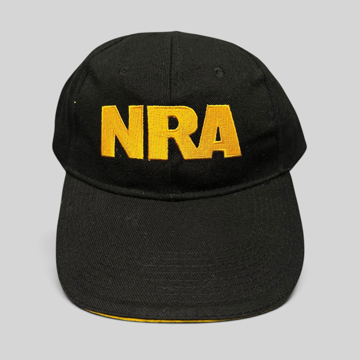 Raree Finds black strapback hat with bold yellow embroidered NRA lettering on the front and a curved brim