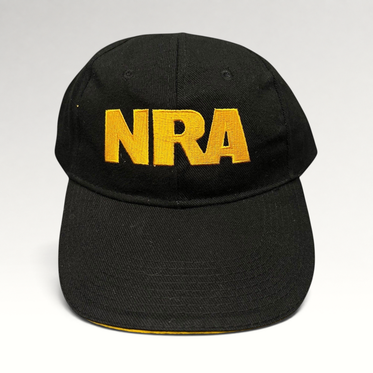 Raree Finds black strapback hat with bold yellow embroidered NRA lettering on the front and a curved brim