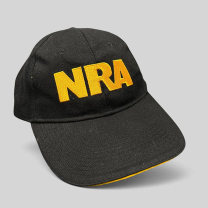 Raree Finds black strapback hat with bold yellow embroidered NRA lettering on the front and a curved brim