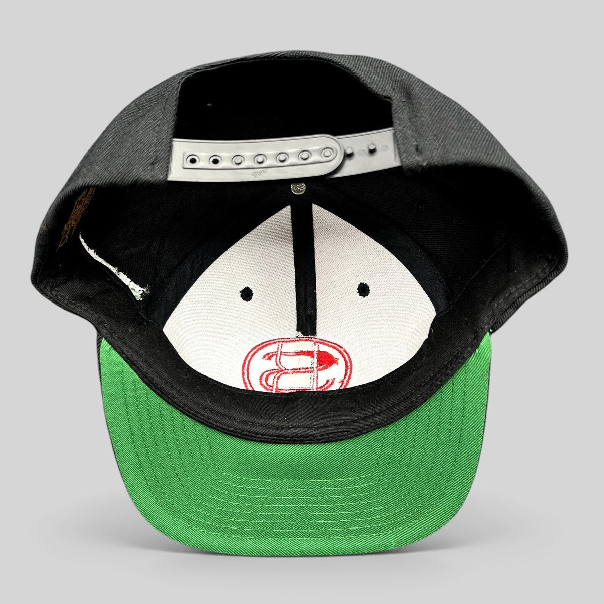 Raree Finds black Yupoong snapback hat with green brim and interior embroidered logo detail
