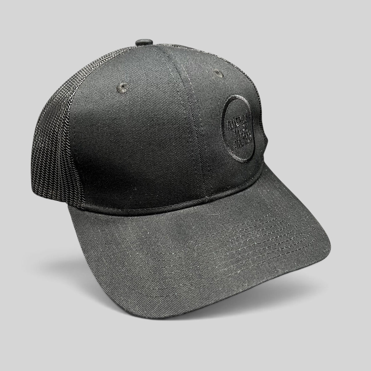 Raree Finds American Music Awards blackout trucker hat with tonal black embroidered logo and mesh back panels.