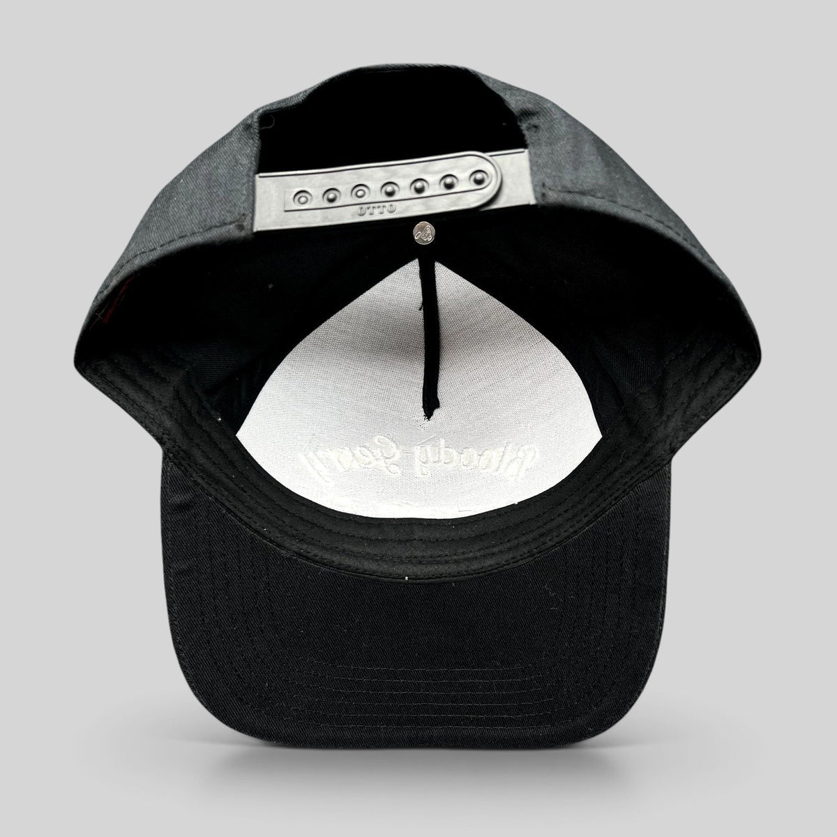 Raree Finds black Bloody Gerry snapback hat showing the adjustable plastic snap closure and interior branding
