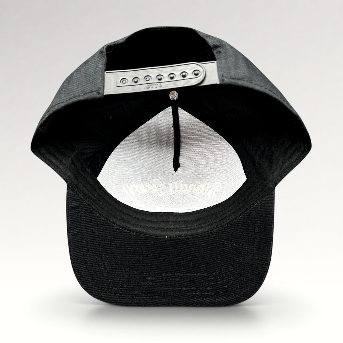 Raree Finds black Bloody Gerry snapback hat showing the adjustable plastic snap closure and interior branding