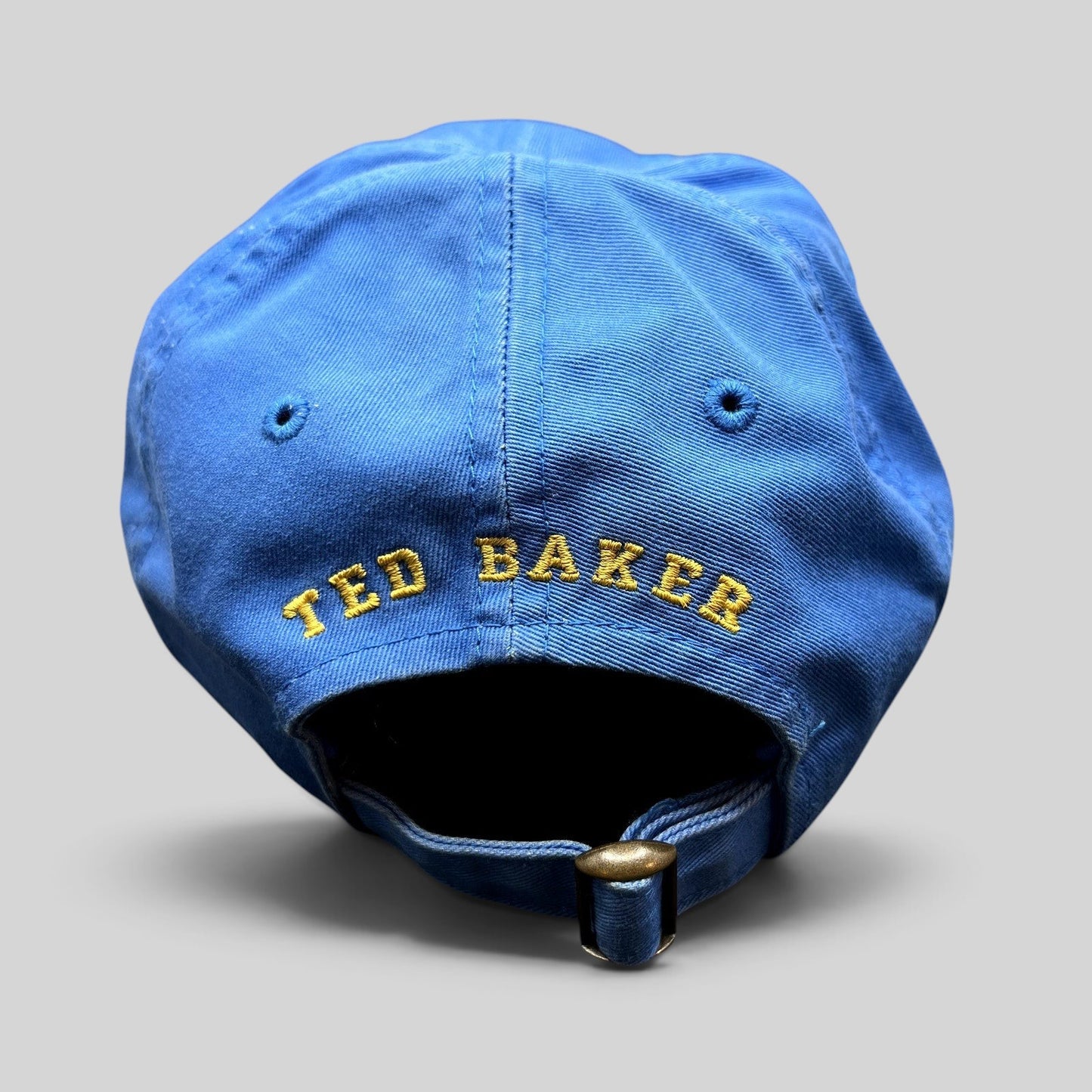 Raree Finds royal blue cotton Ted Baker strapback cap with yellow embroidered rear logo and antique brass buckle