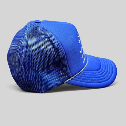 Raree Finds royal blue Otto foam-front trucker hat with white graphic text and mesh back, side profile view.